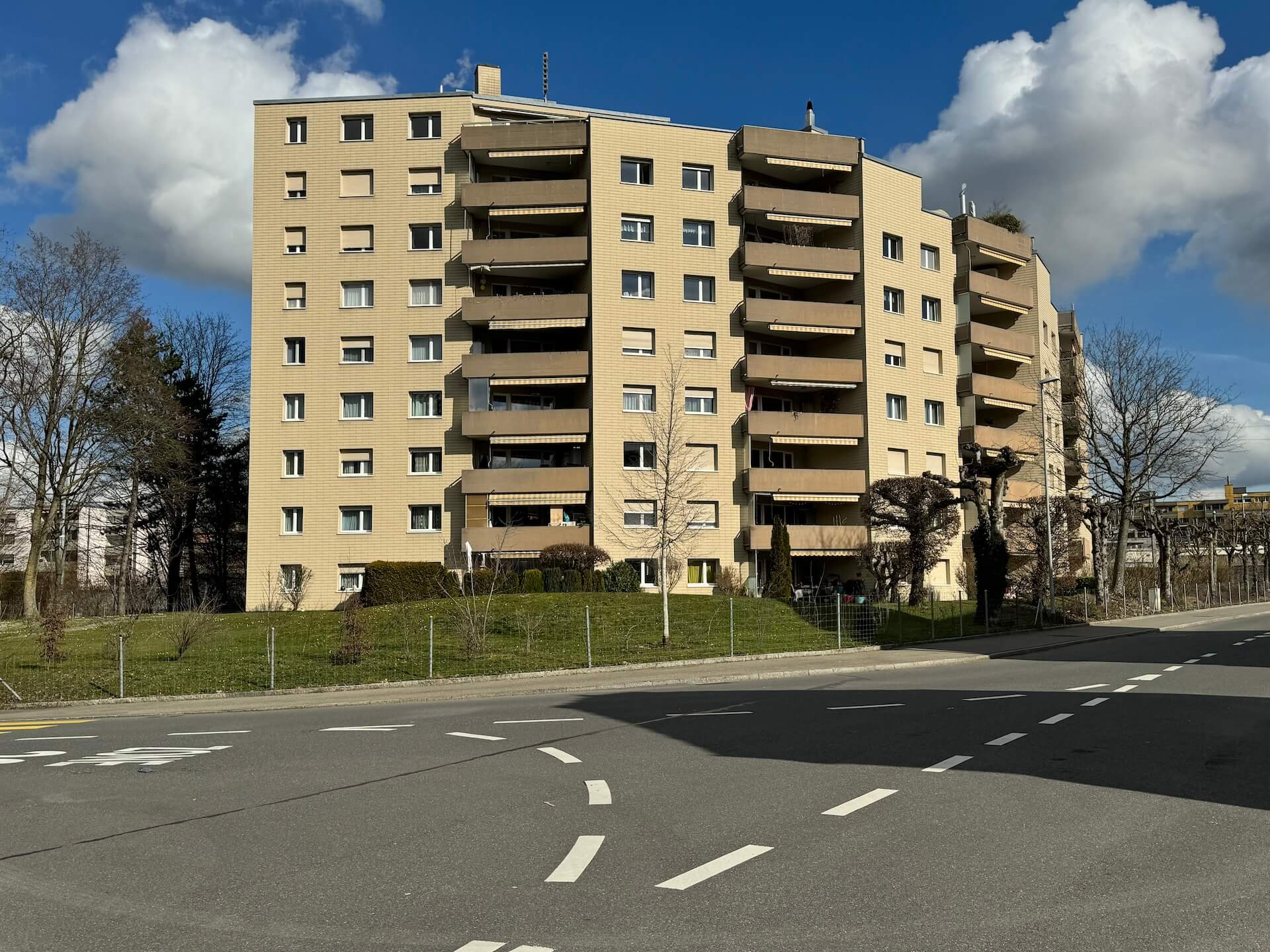Mehrfamilienhaus mit Balkonen an einer Straße