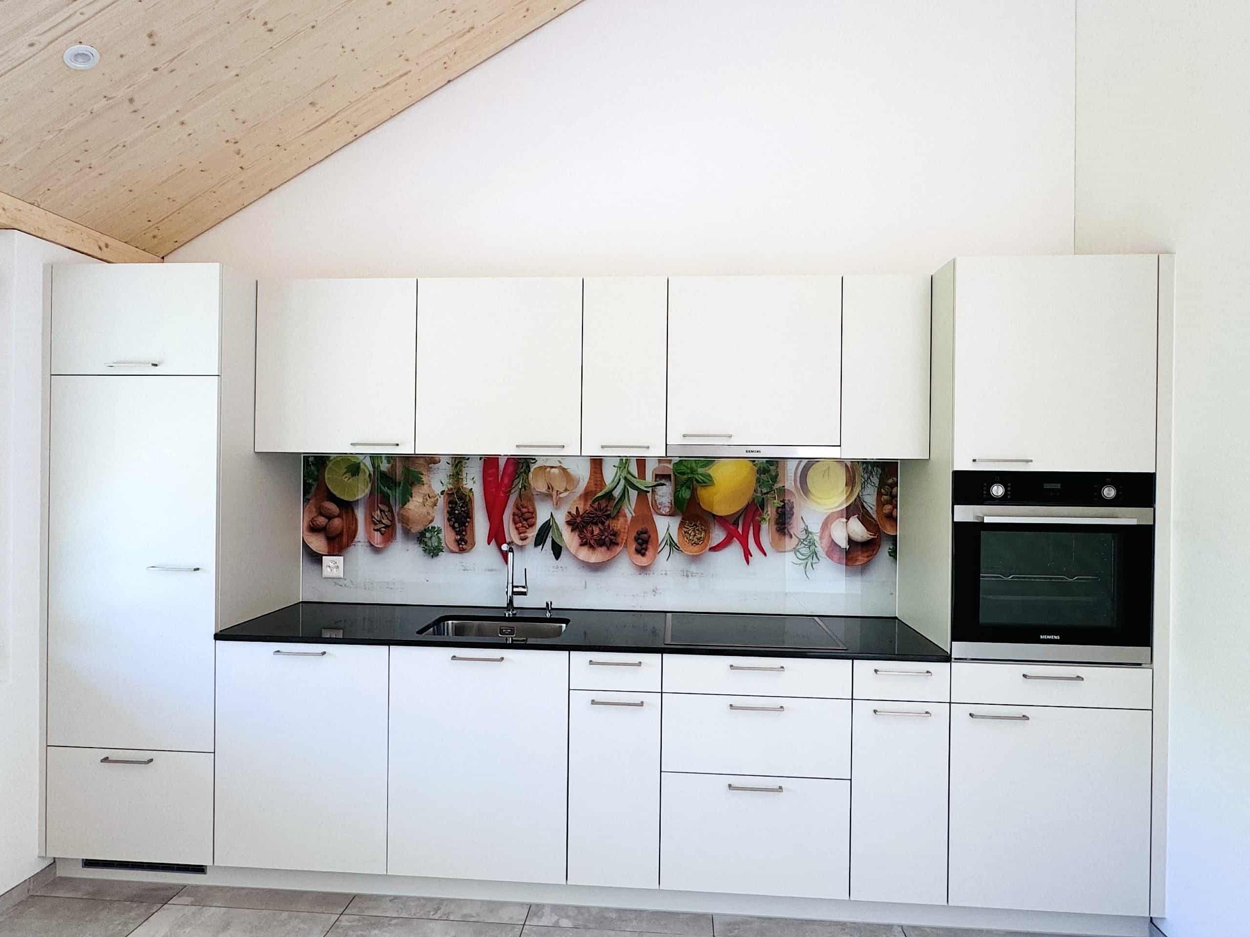 Moderne weiße Einbauküche mit dunkler Arbeitsplatte